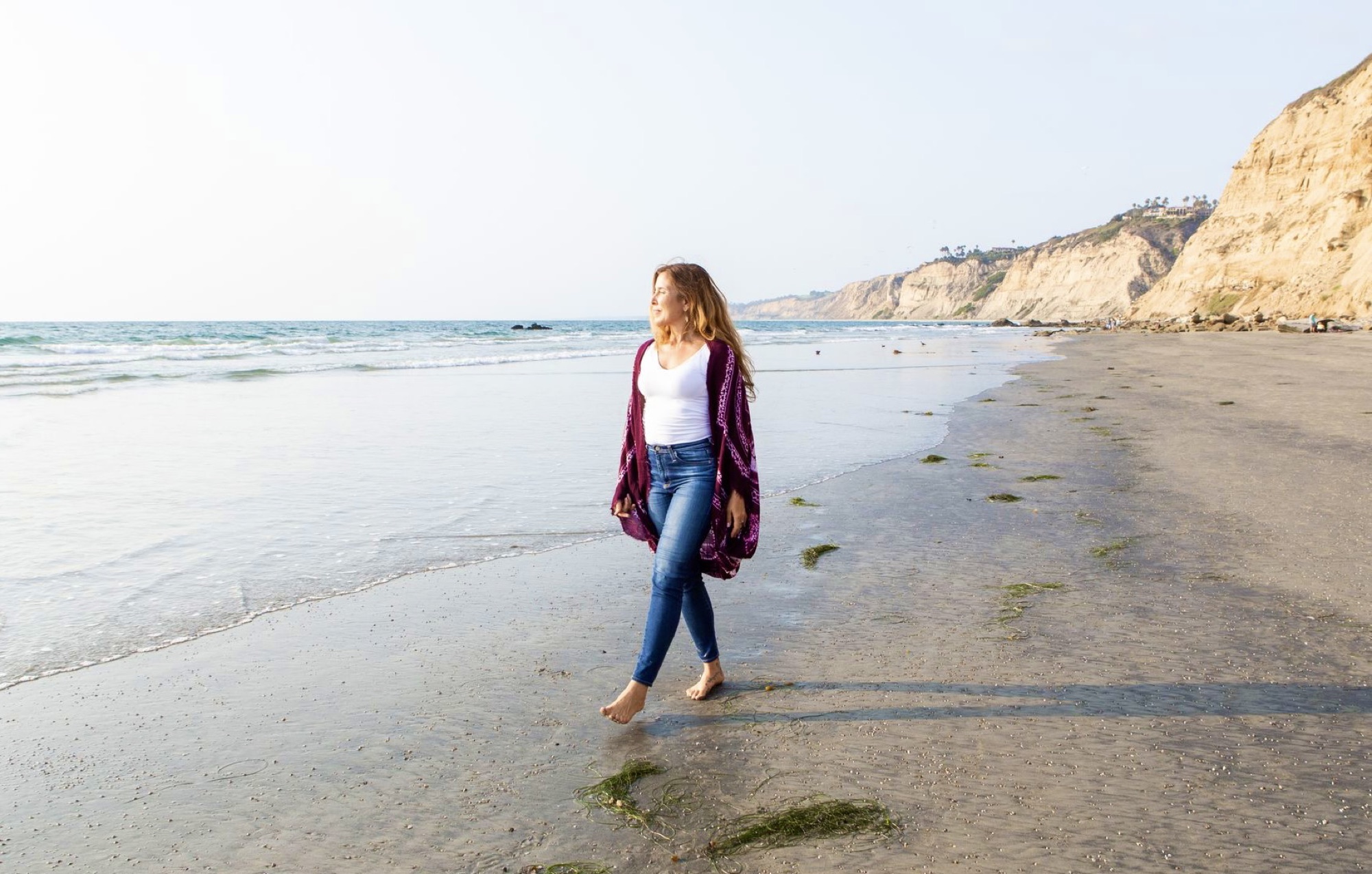 Sienna walking along a Southern California beach below the bluffs